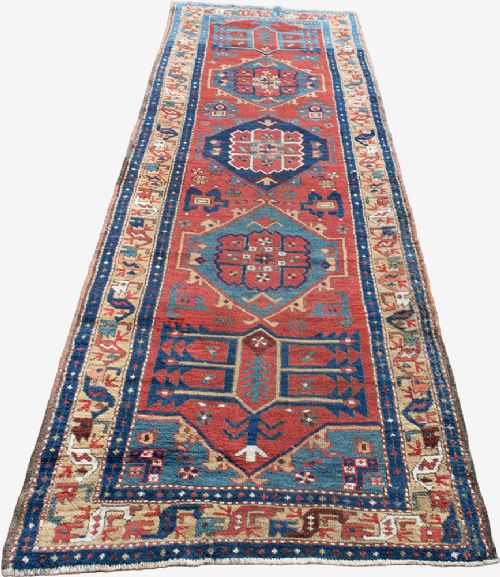 A long hand-knotted antique Heriz runner rug with geometric medallions in red, blue, turquoise, and cream tones. View VI
