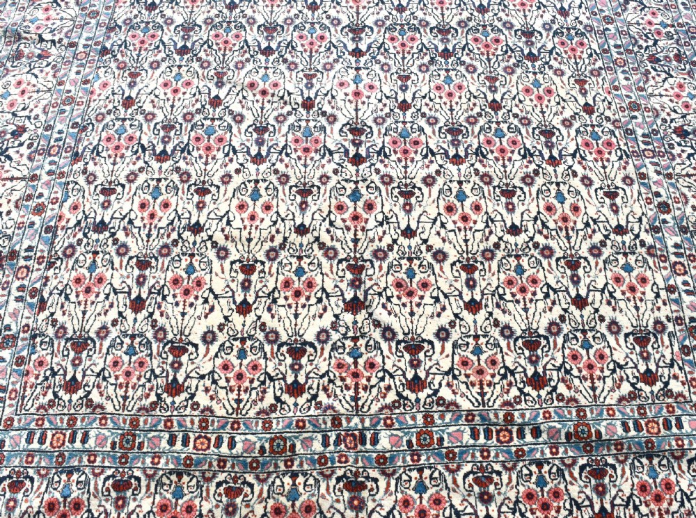 An antique Persian Tehran carpet featuring an intricate overall floral pattern in tones of ivory, blue, and red with a detailed multi-stripe border. View II