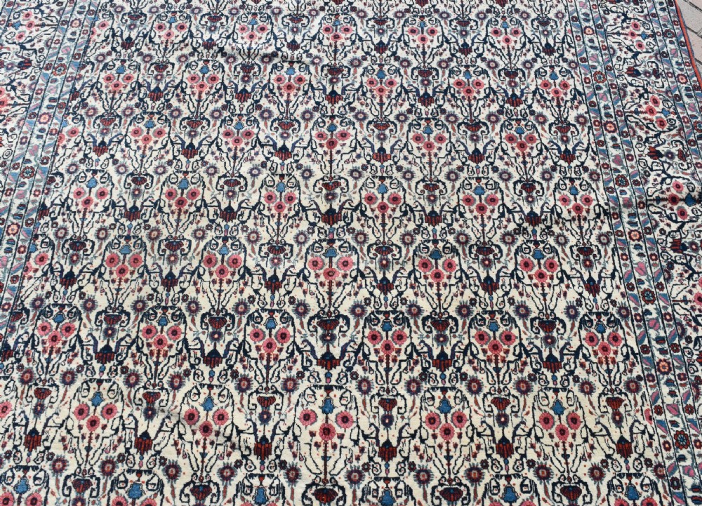 An antique Persian Tehran carpet featuring an intricate overall floral pattern in tones of ivory, blue, and red with a detailed multi-stripe border. View III
