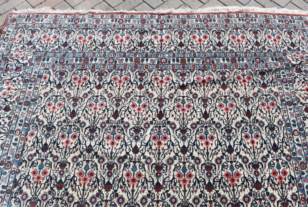 An antique Persian Tehran carpet featuring an intricate overall floral pattern in tones of ivory, blue, and red with a detailed multi-stripe border. View IV