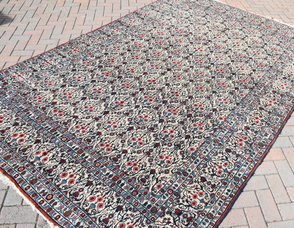 An antique Persian Tehran carpet featuring an intricate overall floral pattern in tones of ivory, blue, and red with a detailed multi-stripe border. View VI