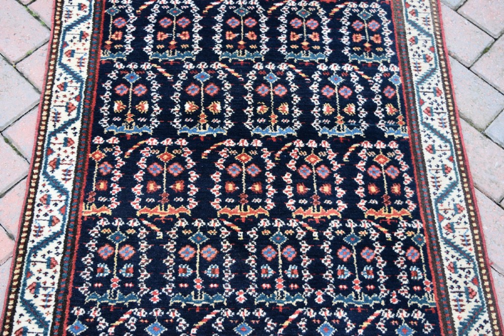 An antique Northwest Persian wool runner rug featuring repeating geometric shrub motifs on a navy blue field framed by a cream border. View VIII