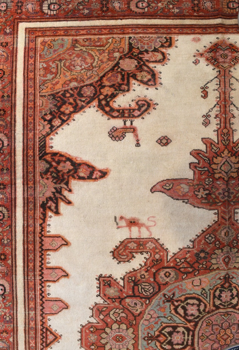 An antique Persian Malayer hand-knotted wool rug featuring a central stepped medallion, stylized lion motifs, and an ivory field framed by terracotta borders. View III