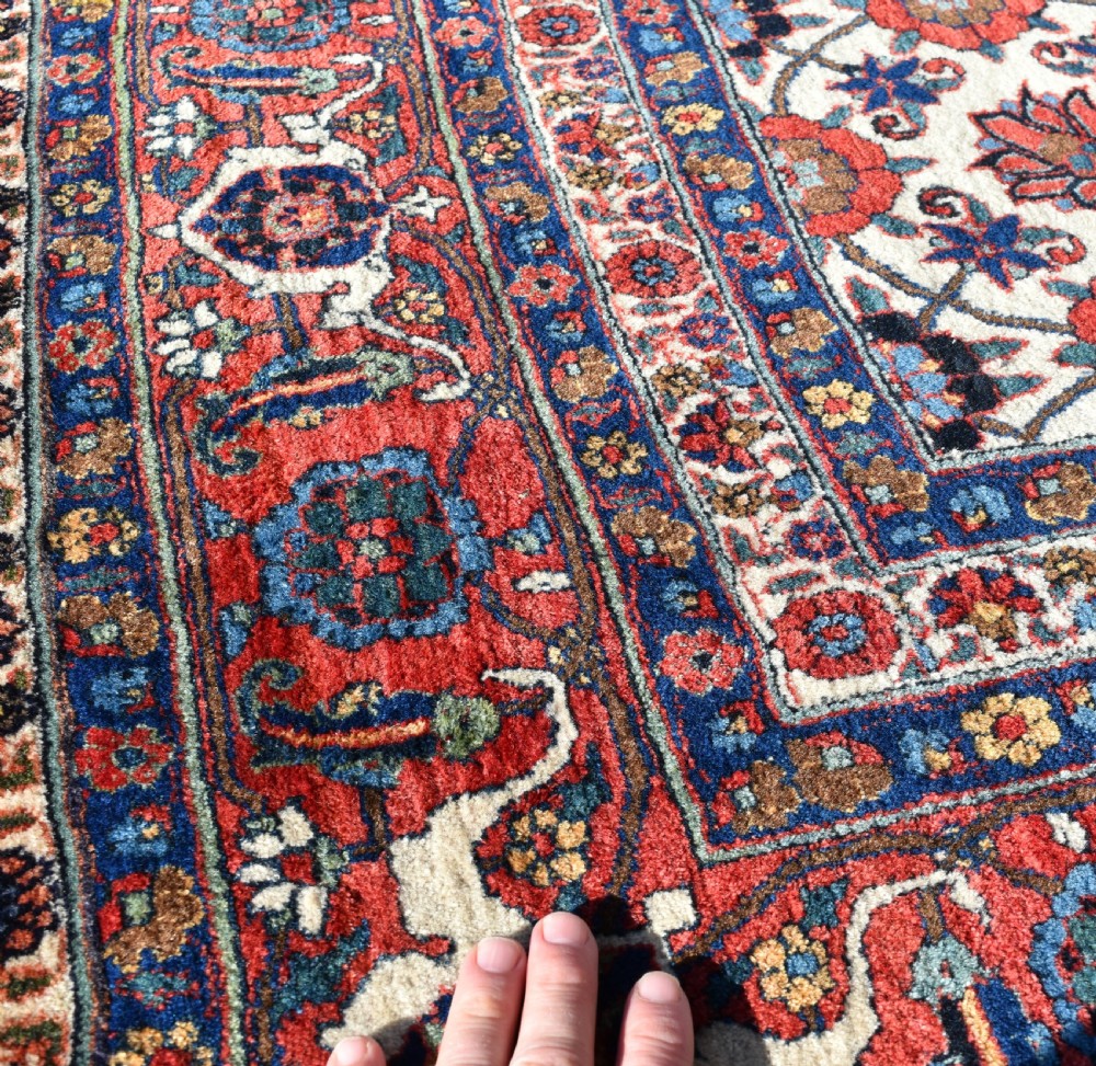 An antique Persian Veramin hand-knotted wool carpet featuring a repeating floral trellis pattern on an ivory field surrounded by multi-band borders. View IV