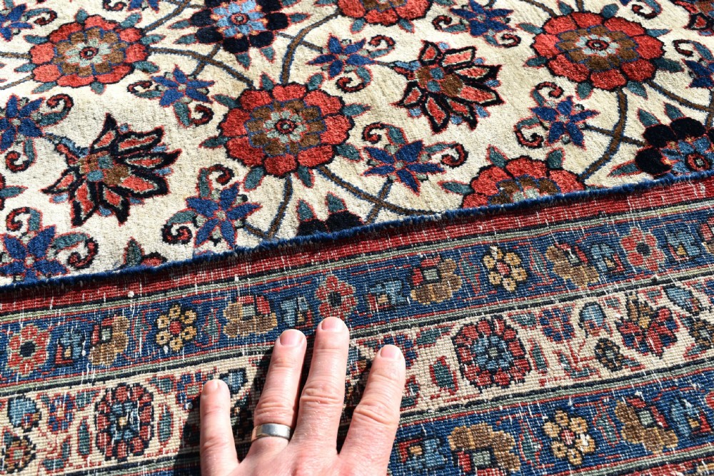 An antique Persian Veramin hand-knotted wool carpet featuring a repeating floral trellis pattern on an ivory field surrounded by multi-band borders. View V