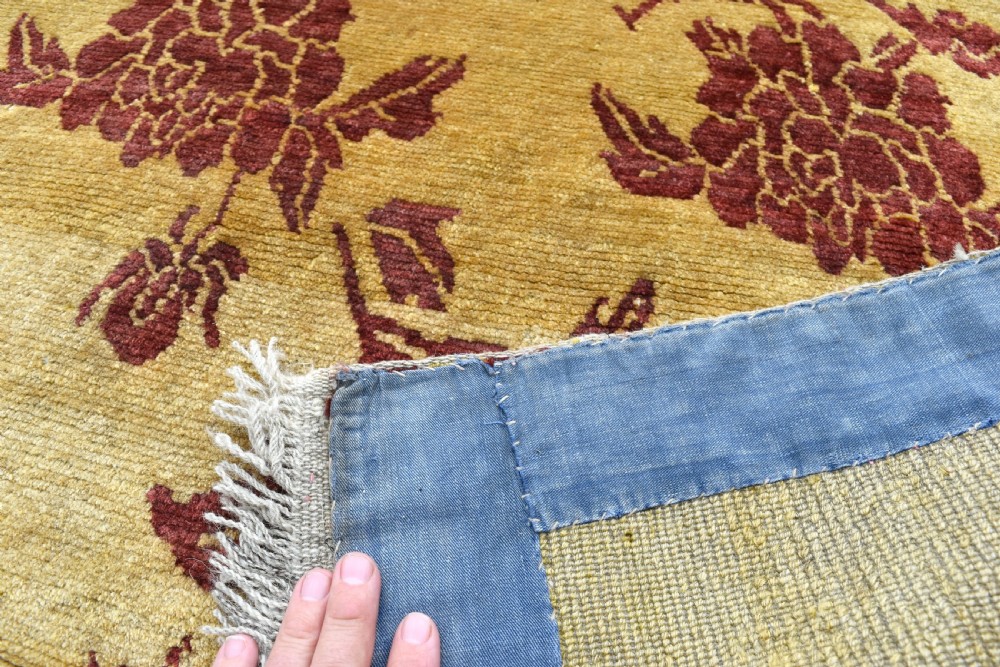 An antique rectangular Tibetan Khaden wool rug featuring a yellow field decorated with crimson floral branch motifs and fringe along the top and bottom edges. View III