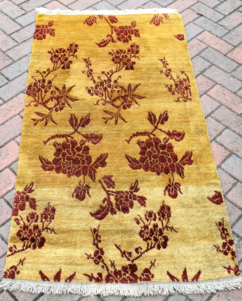 An antique rectangular Tibetan Khaden wool rug featuring a yellow field decorated with crimson floral branch motifs and fringe along the top and bottom edges. View IV