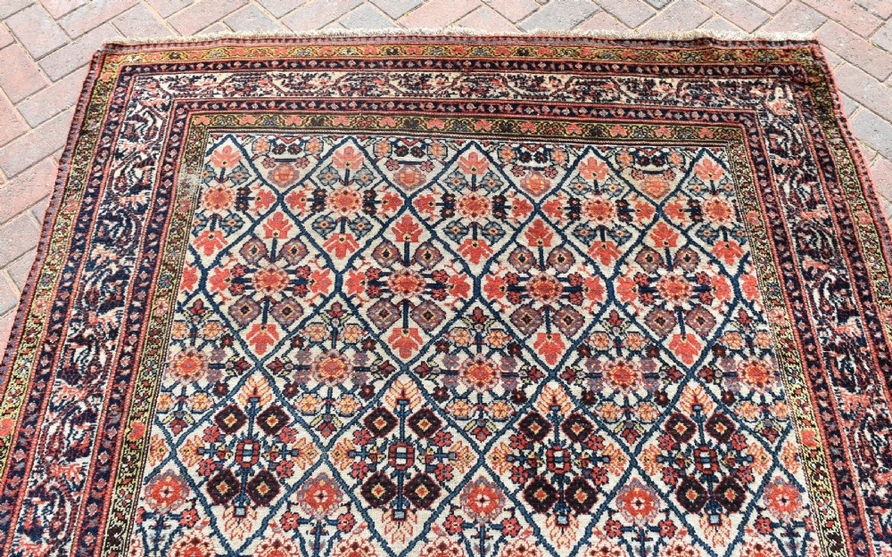 An antique long North West Persian Kelleh carpet featuring an intricate repeating lattice geometric motif in terracotta, navy blue, and cream tones. View VI