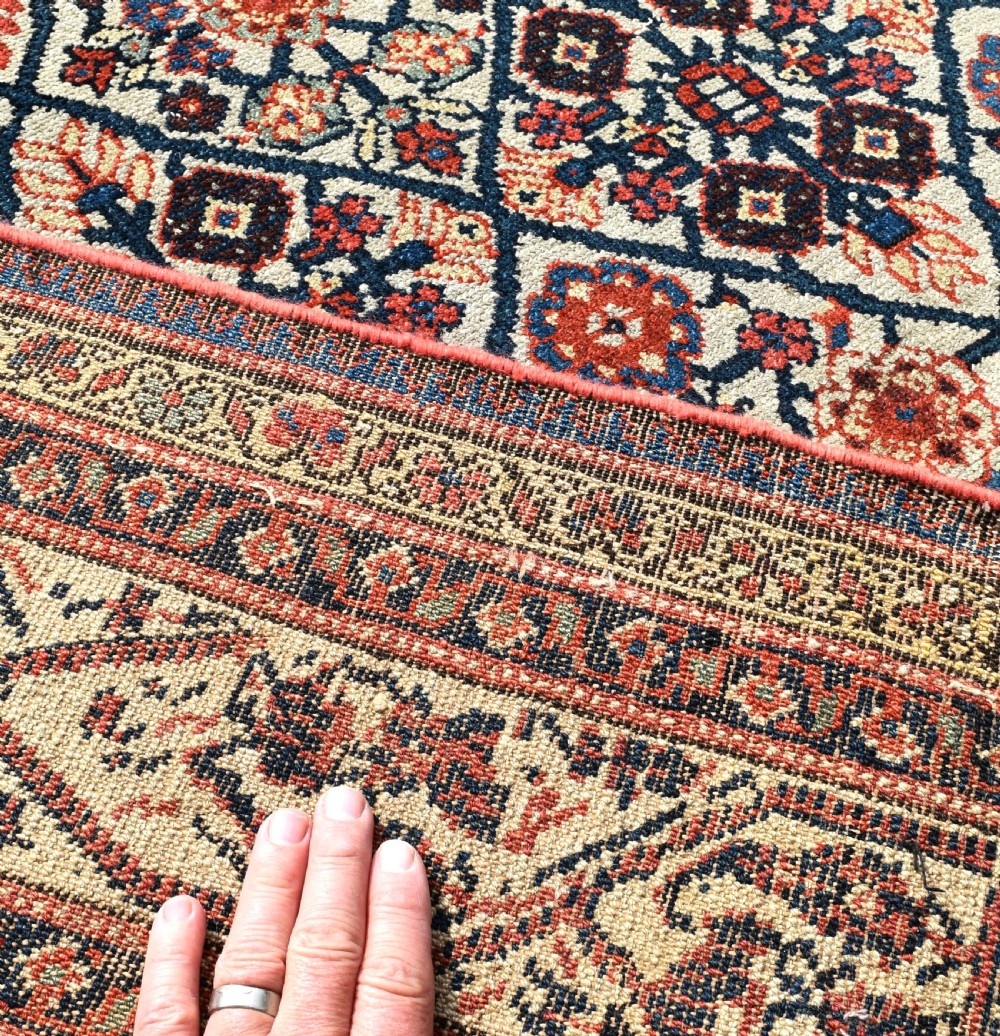 An antique long North West Persian Kelleh carpet featuring an intricate repeating lattice geometric motif in terracotta, navy blue, and cream tones. View VIII