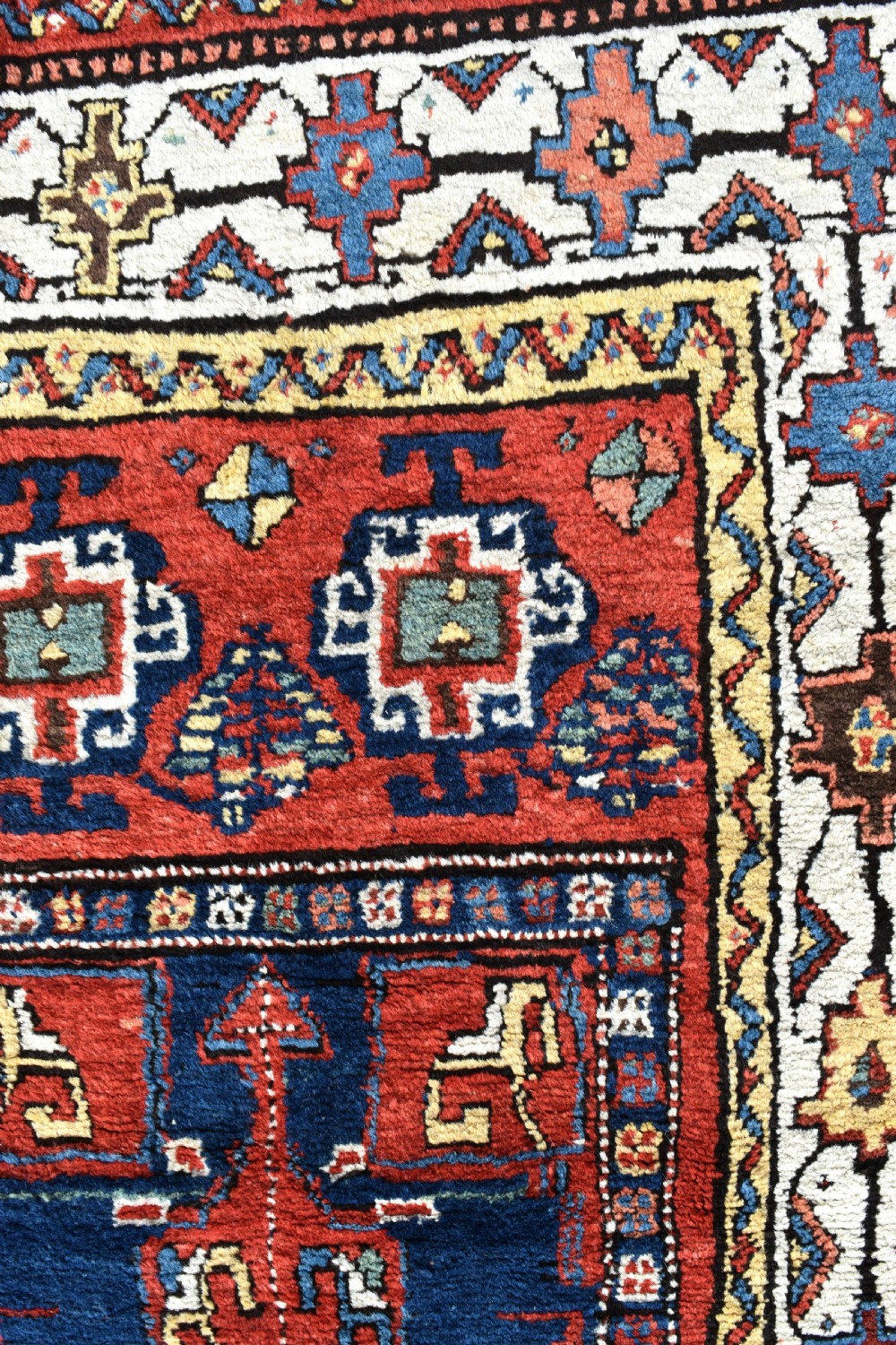 An antique Shahsavan hand-knotted wool long rug featuring geometric medallions in terracotta red, navy blue, yellow, and white. View II