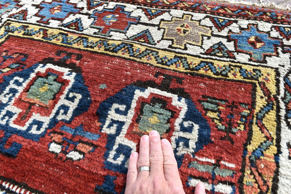 An antique Shahsavan hand-knotted wool long rug featuring geometric medallions in terracotta red, navy blue, yellow, and white. View III