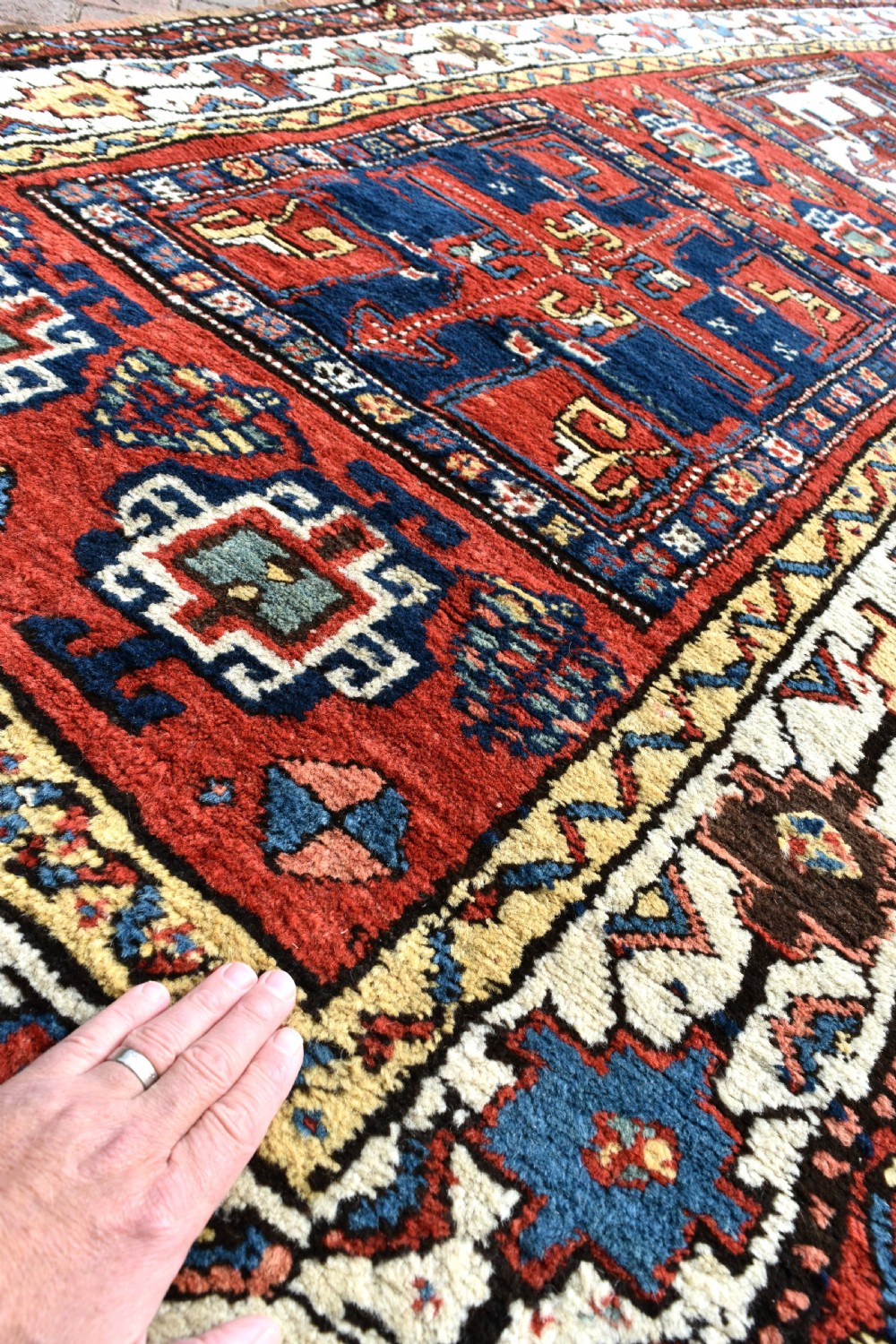An antique Shahsavan hand-knotted wool long rug featuring geometric medallions in terracotta red, navy blue, yellow, and white. View V