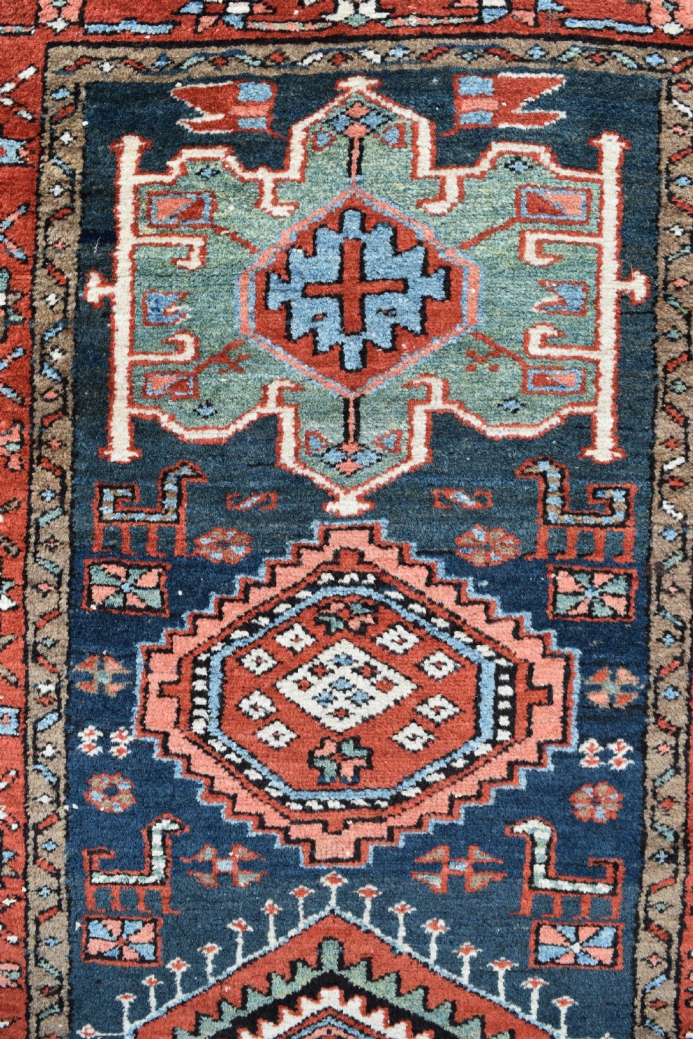 A long hand-knotted Persian Heriz runner rug featuring geometric diamond medallions on a navy blue field with terracotta red borders. View II