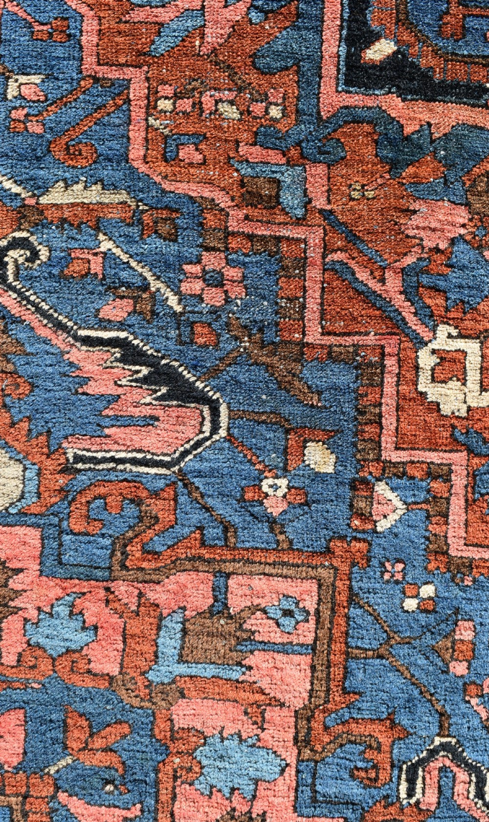 An antique hand-knotted Persian Heriz wool carpet featuring a large sky blue geometric medallion on a terracotta ground surrounded by a dark navy ornate border. View VIII