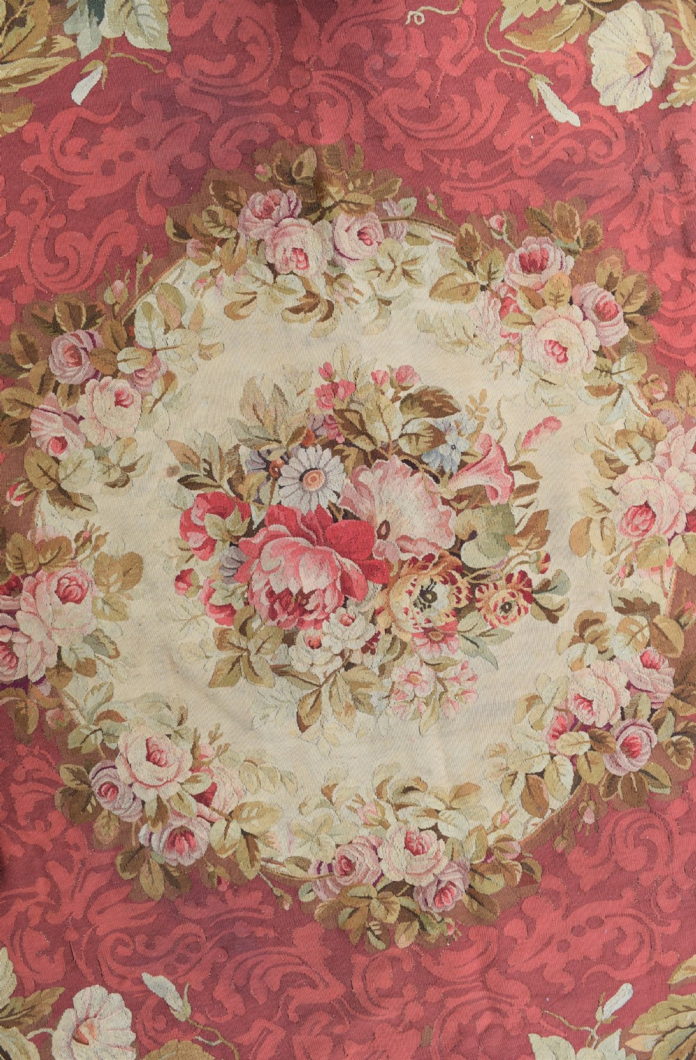 A square antique French Aubusson flatweave rug featuring a central pink floral medallion surrounded by a rose red field and ornate scroll borders. View II