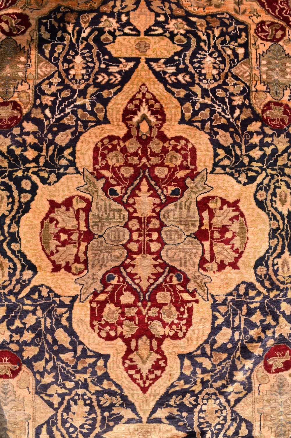An antique hand-knotted Turkish Sivas rug featuring a central crimson medallion surrounded by navy spandrels and detailed floral borders in beige and blue tones. View V