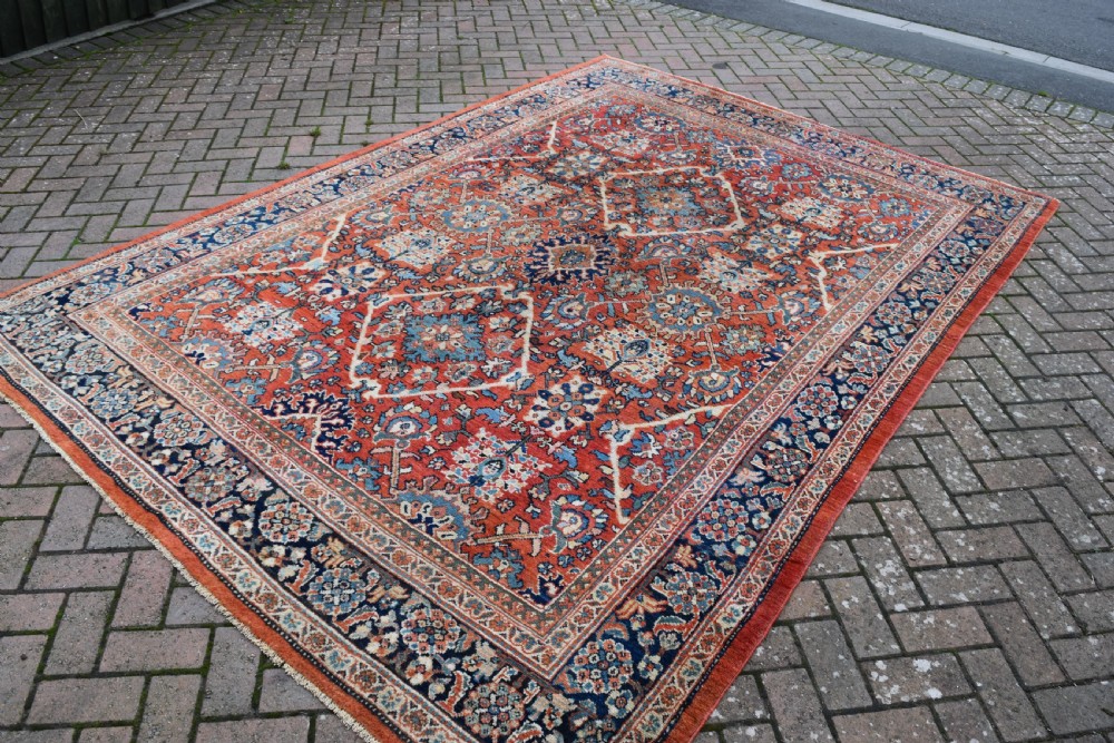 A hand-knotted Persian Mahal carpet featuring a terracotta central field with intricate floral and diamond medallions enclosed within a dark navy blue floral border. View II