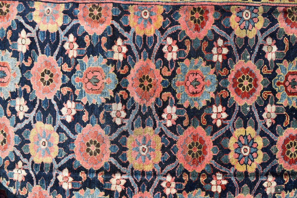 An elongated hand-knotted antique wool Kurdish Kelleh carpet featuring a repeating floral lattice pattern on a dark navy field surrounded by a patterned red border. View II
