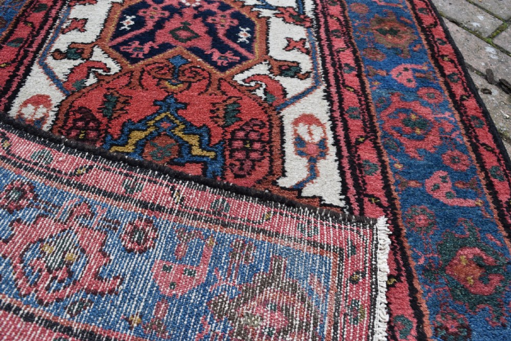 An extra long antique Persian Malayer runner rug featuring repeating geometric medallions on an ivory field with red and navy blue borders. View IV