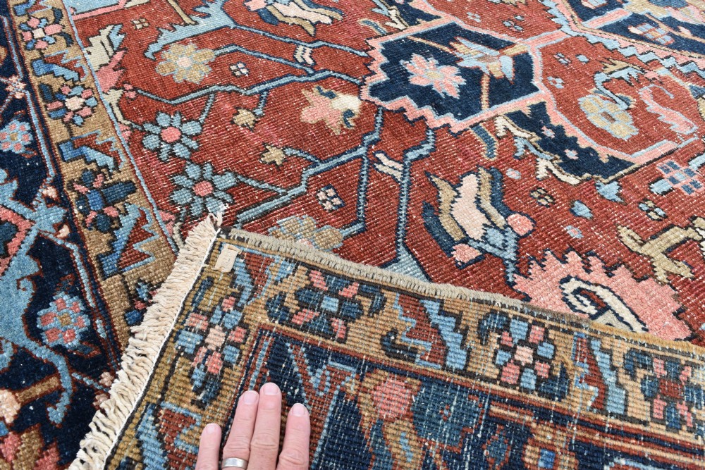 An antique hand-knotted Persian Heriz carpet featuring a large geometric central medallion in navy blue, light blue, and terracotta surrounded by ornate botanical borders. View II