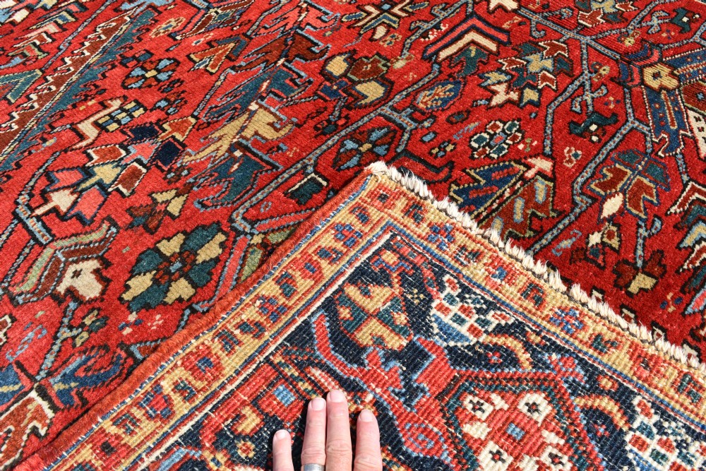A large hand-knotted Persian Heriz carpet displaying a dense geometric all-over motif in terracotta red, sky blue, and navy blue. View II