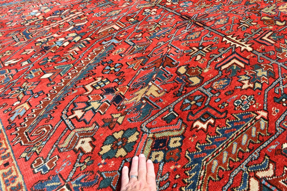 A large hand-knotted Persian Heriz carpet displaying a dense geometric all-over motif in terracotta red, sky blue, and navy blue. View VII