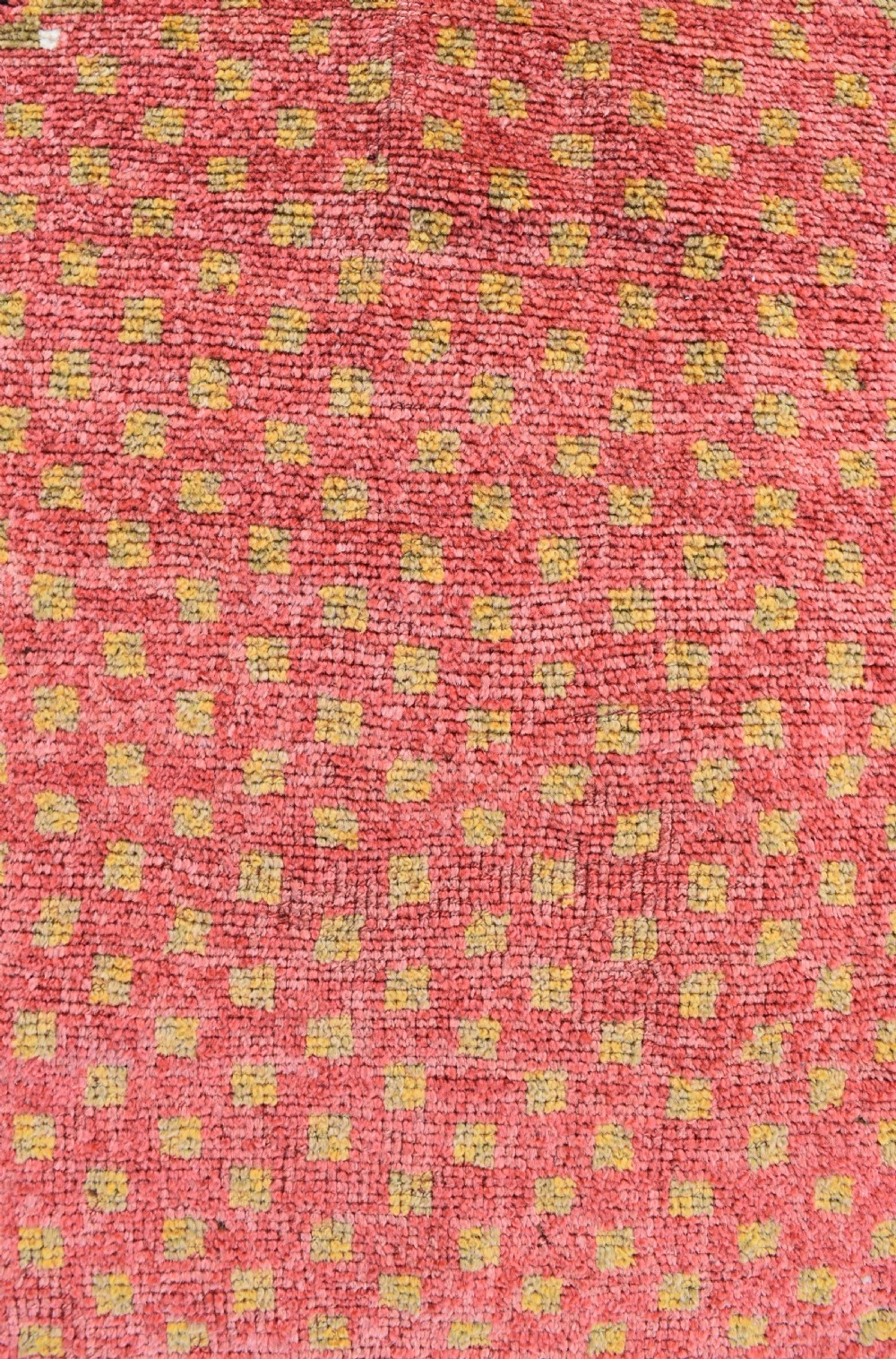 An antique hand-knotted wool Monastir prayer rug featuring a pink and red stepped mihrab arch enclosed by a wide off-white border with colourful rosette motifs. View III