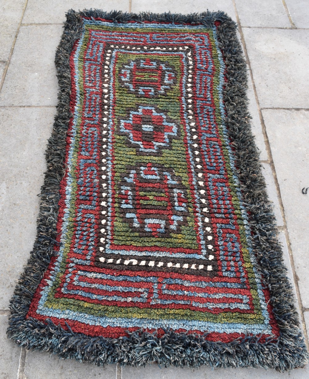 A rare green ground Tibetan monastic seating mat from the Wangden valley, Tibet