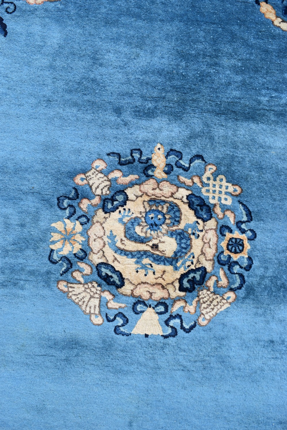 A rectangular hand-knotted wool carpet featuring a bright blue central field decorated with circular floral medallions and a broad beige geometric border. View III