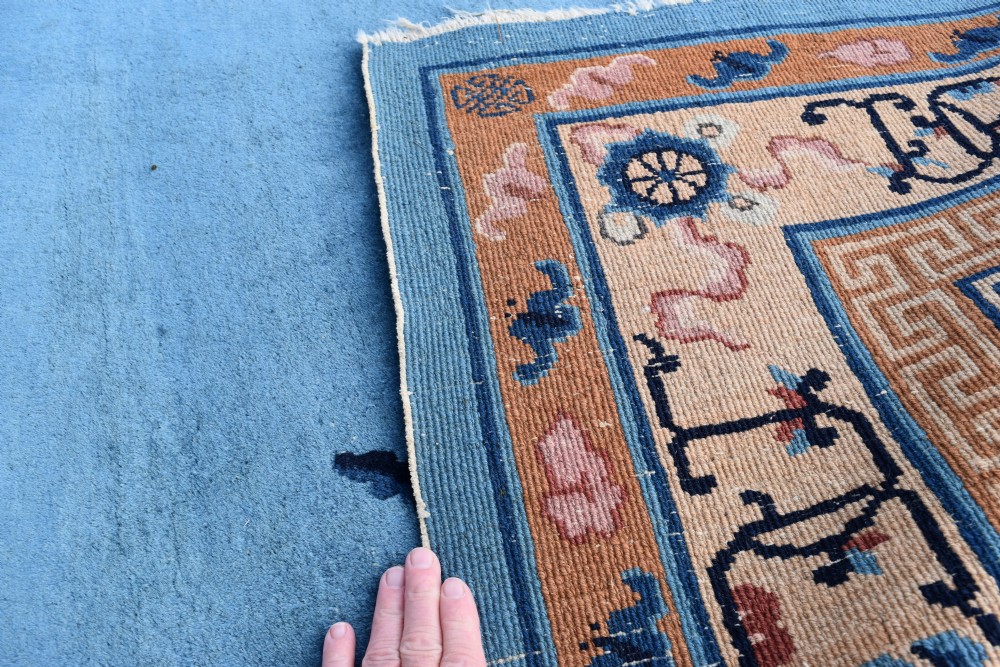 A rectangular hand-knotted wool carpet featuring a bright blue central field decorated with circular floral medallions and a broad beige geometric border. View VI