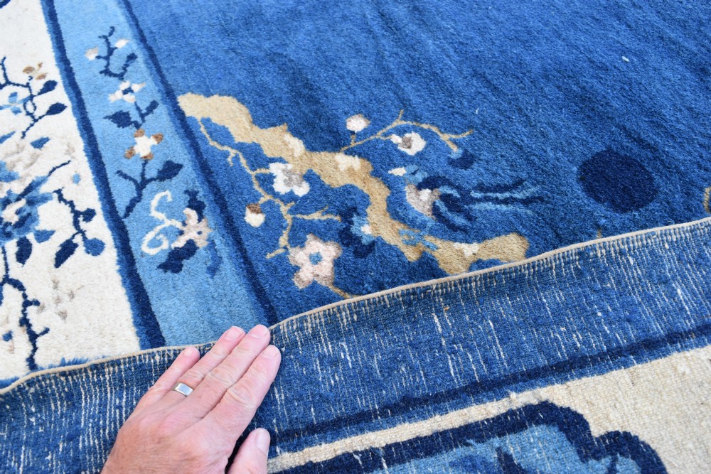 An antique blue and cream Chinese Peking carpet featuring floral motifs and a central bird design within decorative borders. View II