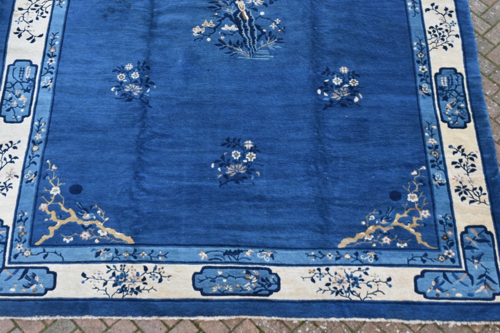 An antique blue and cream Chinese Peking carpet featuring floral motifs and a central bird design within decorative borders. View III