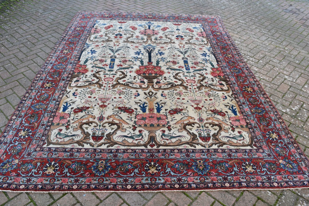 A large hand-knotted Persian Qum carpet featuring an ivory central field patterned with birds, urns, and floral motifs within a dark red border. View II