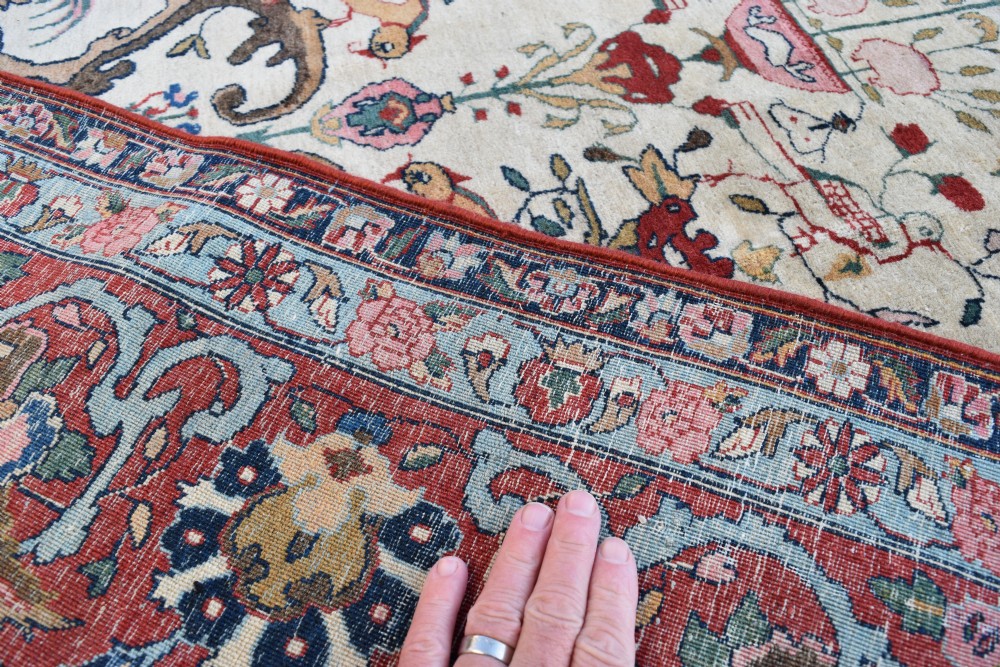 A large hand-knotted Persian Qum carpet featuring an ivory central field patterned with birds, urns, and floral motifs within a dark red border. View VIII