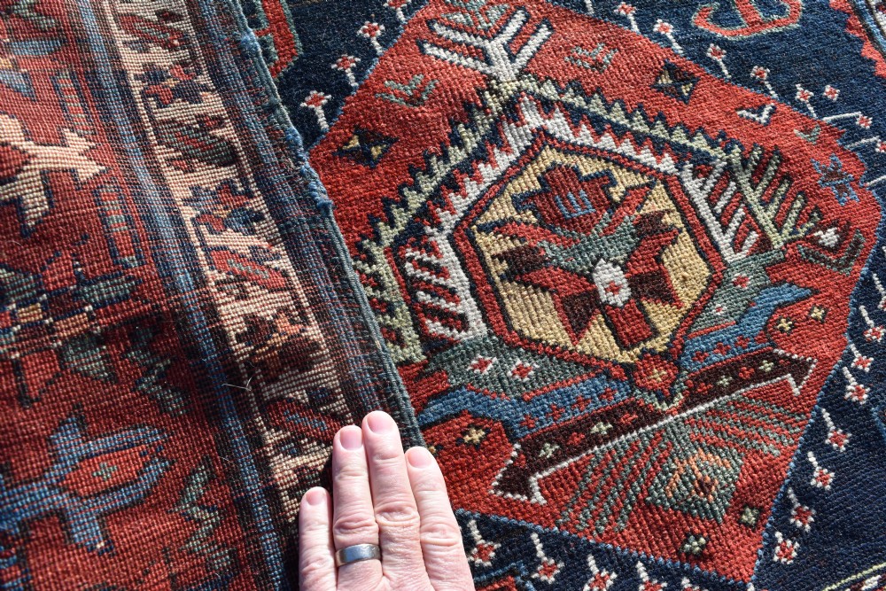 An antique Karadagh hand-knotted wool runner rug featuring geometric medallions on a navy blue central field framed by a wide terracotta red patterned border. View V