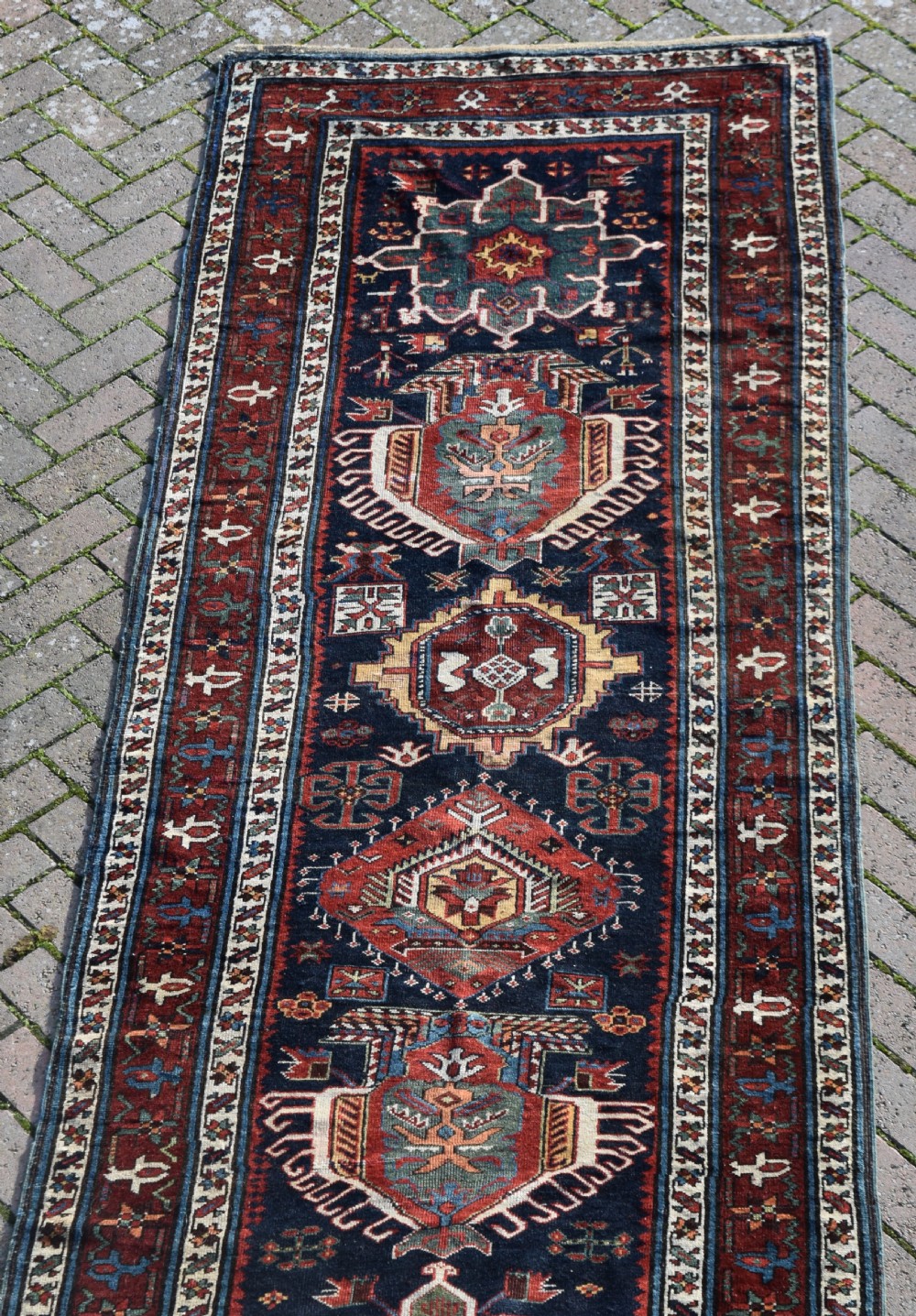 An antique Karadagh hand-knotted wool runner rug featuring geometric medallions on a navy blue central field framed by a wide terracotta red patterned border. View VIII