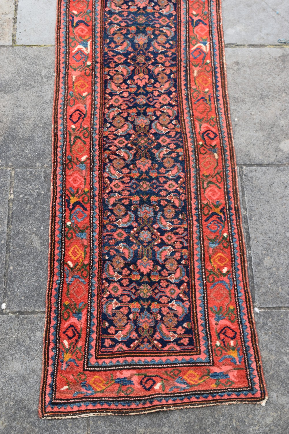 A long narrow hand-knotted antique Kurdish wool rug runner featuring a dark navy central field with repeating floral lattice patterns framed by a terracotta border. View II