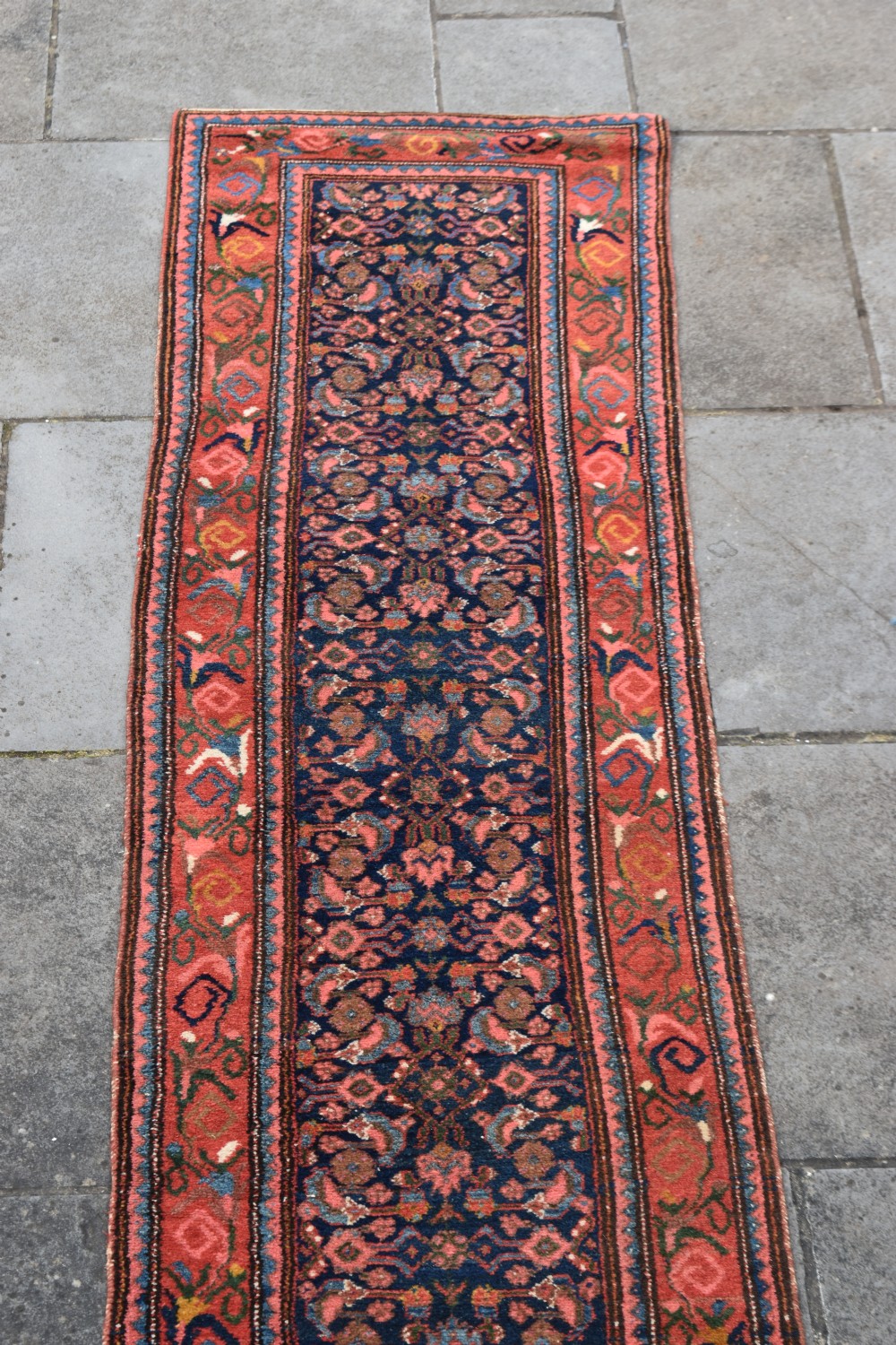 A long narrow hand-knotted antique Kurdish wool rug runner featuring a dark navy central field with repeating floral lattice patterns framed by a terracotta border. View VIII
