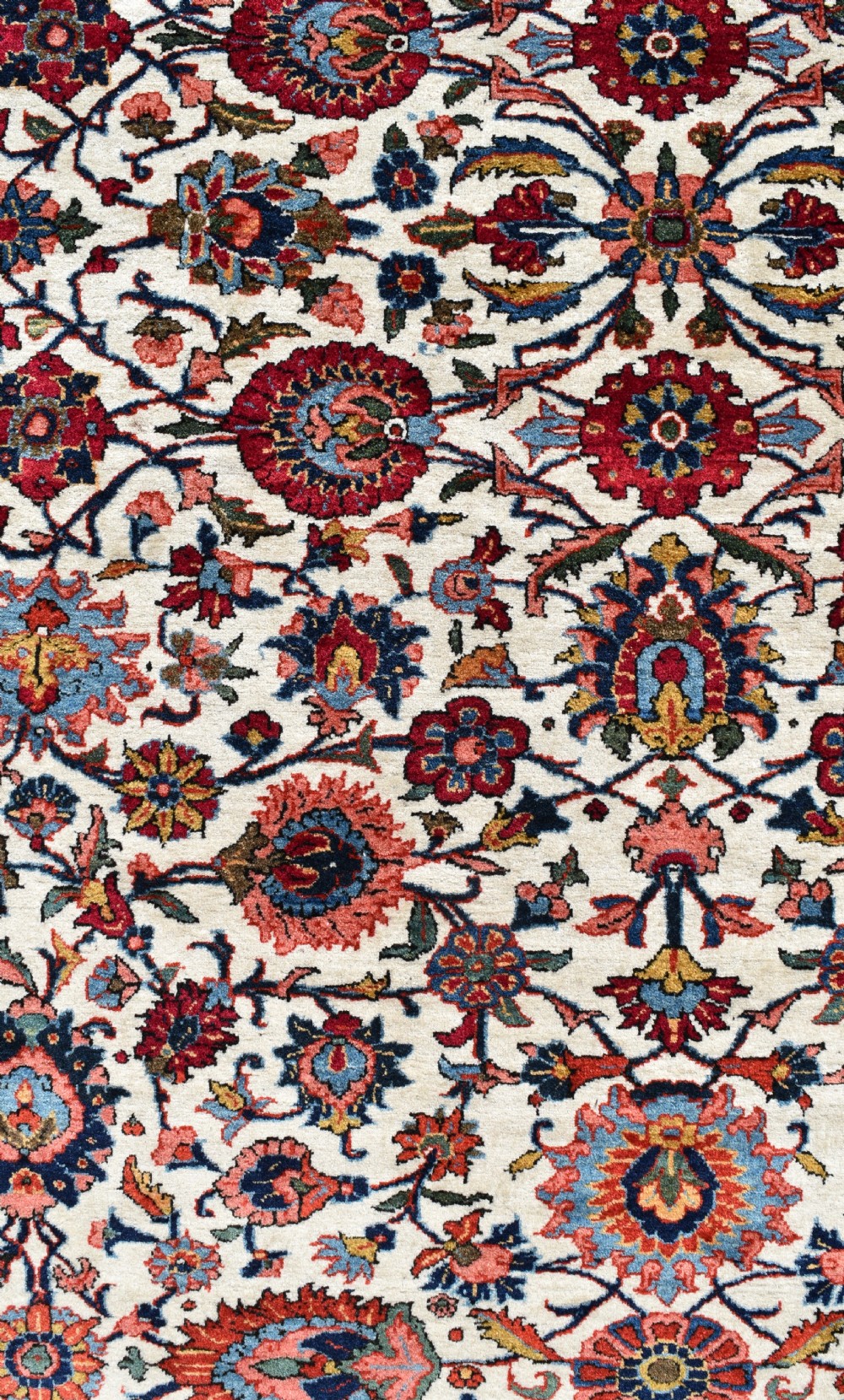 An antique hand-knotted Persian Qum rug featuring an ivory field filled with red and blue floral motifs, surrounded by a multi-band decorative border. View III