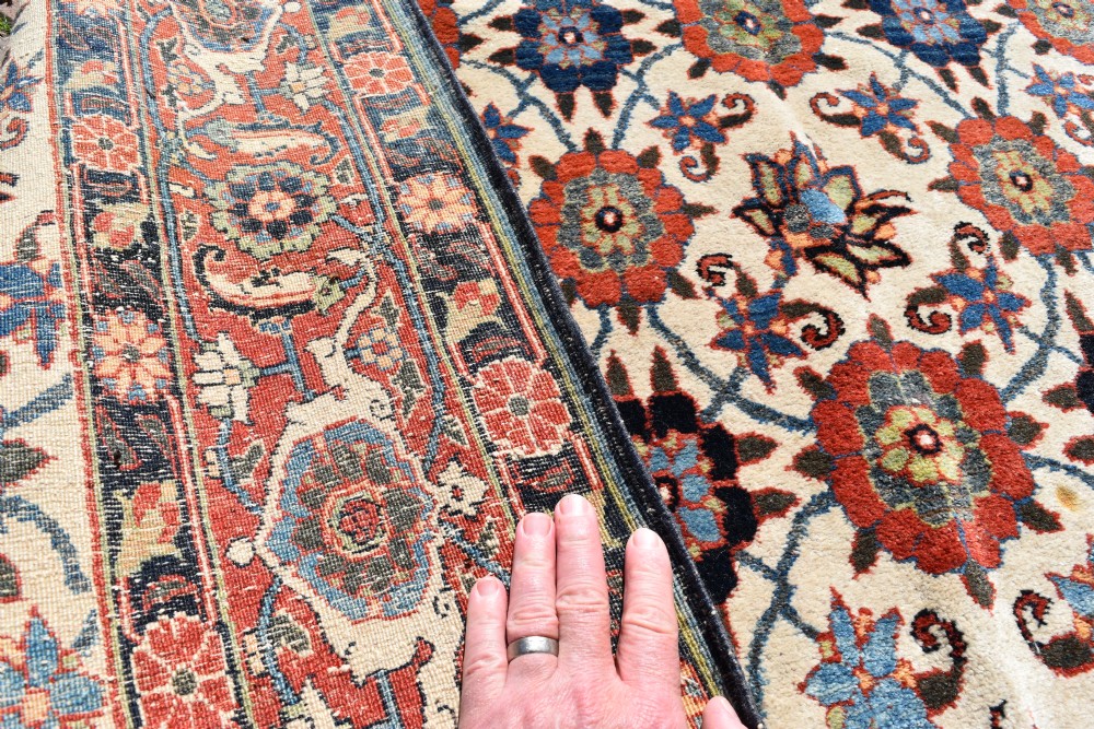 An antique hand-knotted Persian Veramin rug displaying a repeated Mina Khani floral pattern on a cream field framed by multiple dark red and blue decorative borders. View V