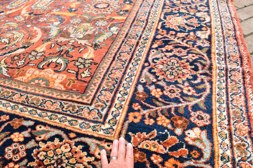An oversized antique Persian Mahal wool carpet with a floral arabesque pattern on a terracotta field and a dark navy border. View V