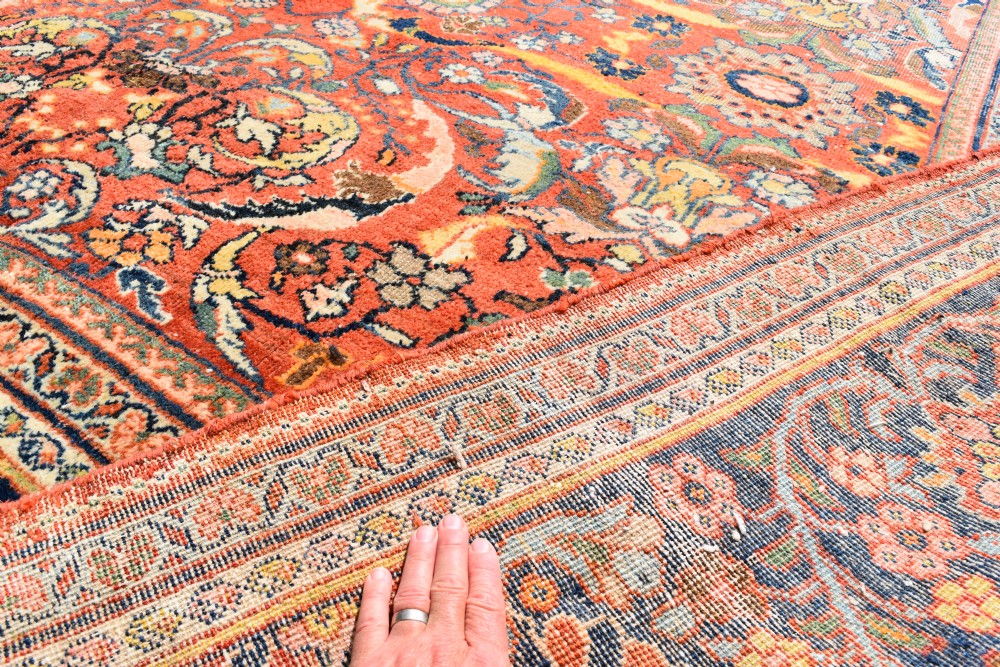 An oversized antique Persian Mahal wool carpet with a floral arabesque pattern on a terracotta field and a dark navy border. View VI