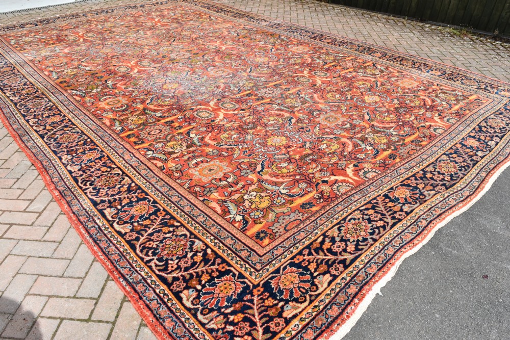 An oversized antique Persian Mahal wool carpet with a floral arabesque pattern on a terracotta field and a dark navy border. View VIII