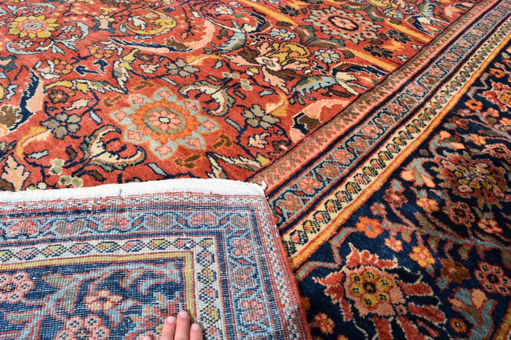 An oversized antique Persian Mahal wool carpet with a floral arabesque pattern on a terracotta field and a dark navy border. View IX