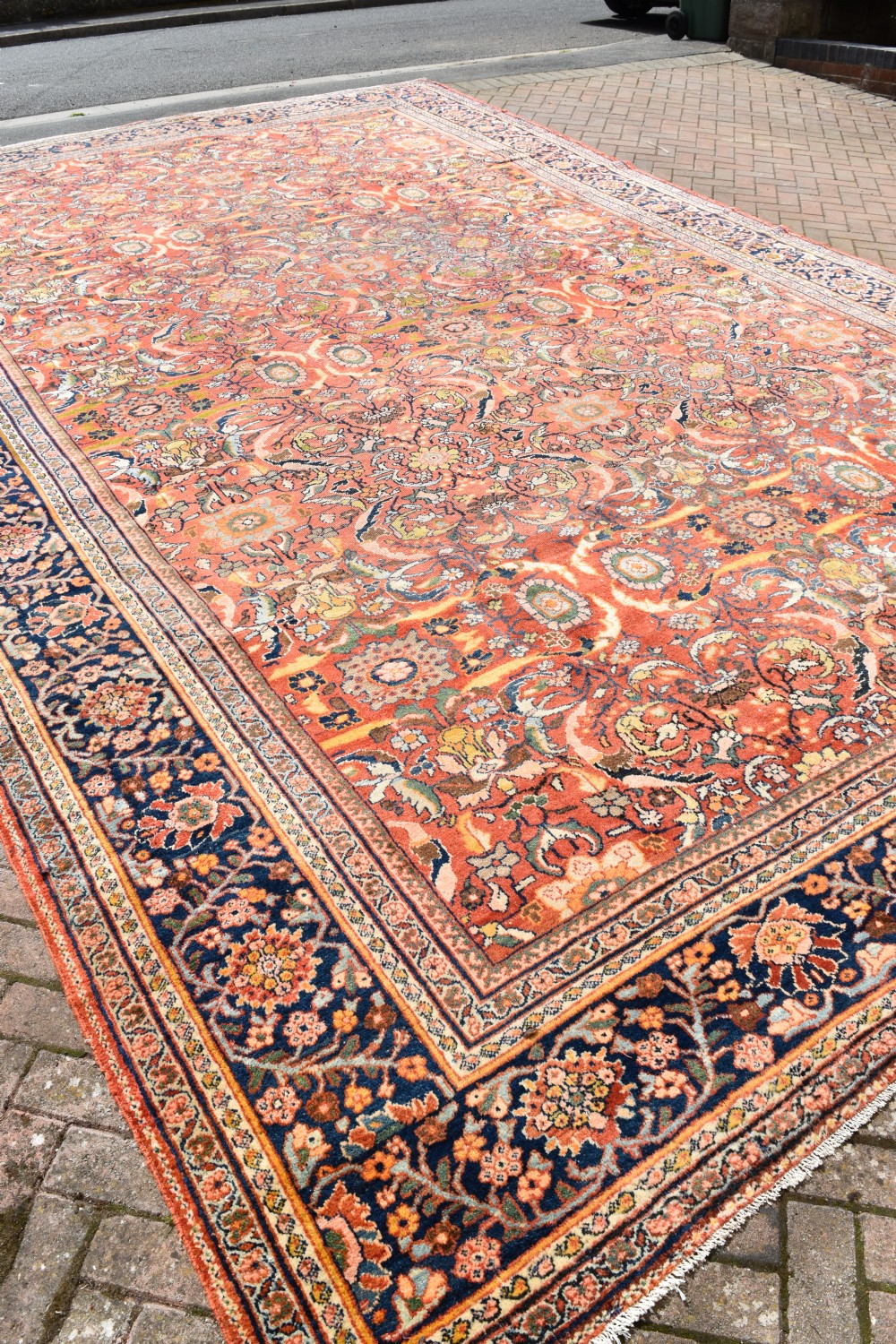An oversized antique Persian Mahal wool carpet with a floral arabesque pattern on a terracotta field and a dark navy border. View X