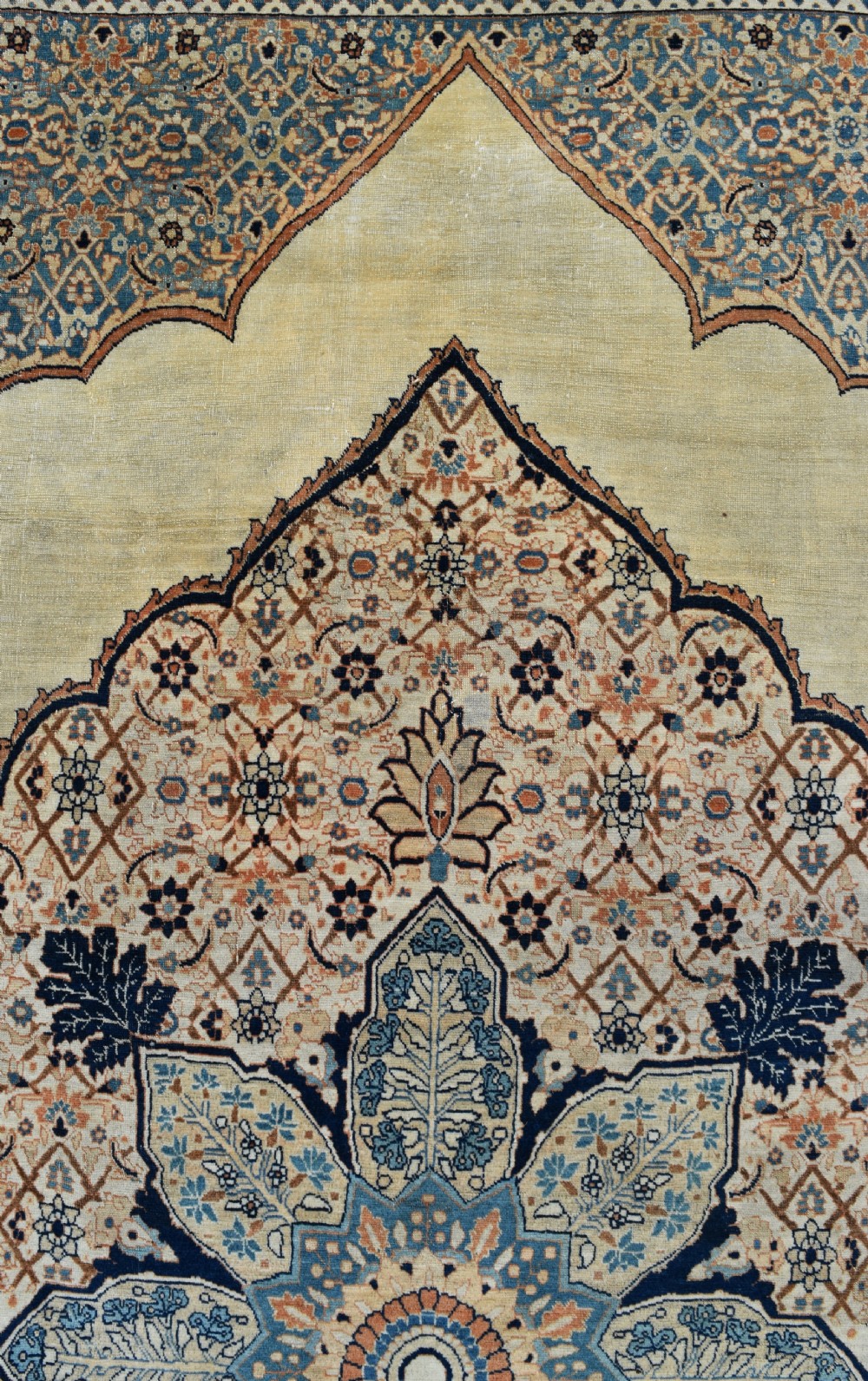 A large hand-knotted antique Persian Hajji Jalili carpet featuring a central star-shaped medallion on a cream field surrounded by dark blue floral borders. View V
