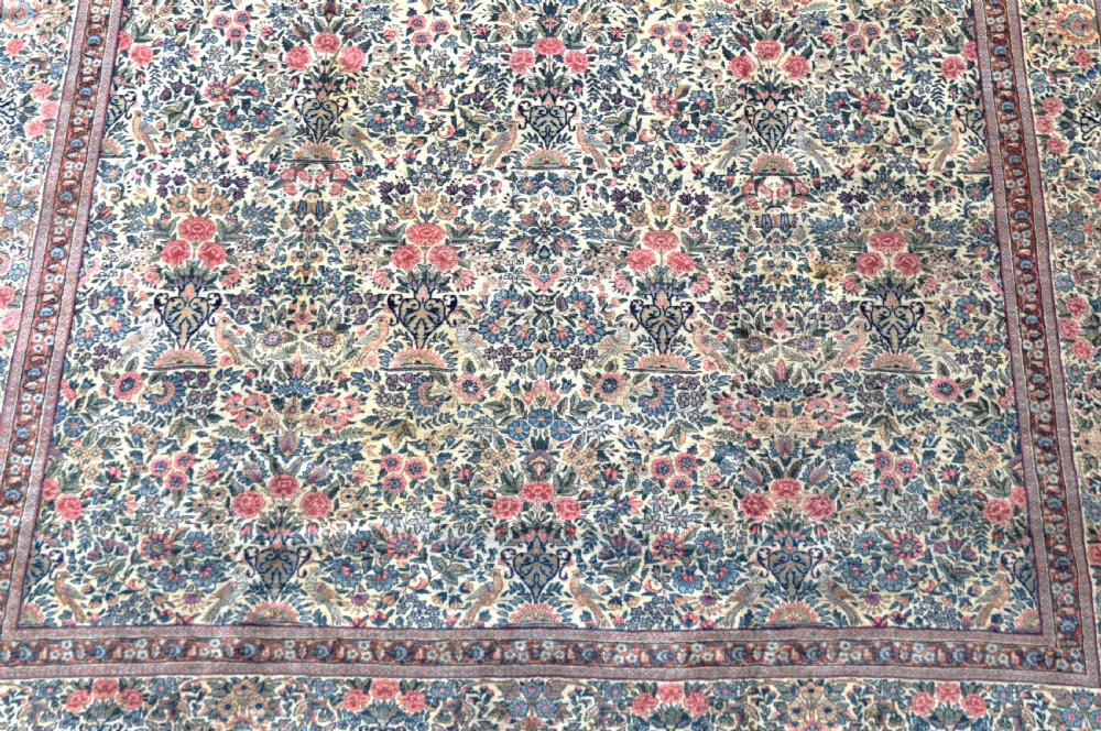 A large hand-knotted Persian Kirman room-size carpet featuring an intricate floral and vase pattern in cream, rose pink, and slate blue. View II