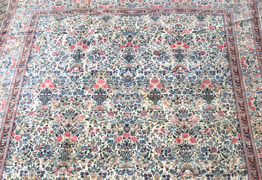 A large hand-knotted Persian Kirman room-size carpet featuring an intricate floral and vase pattern in cream, rose pink, and slate blue. View III