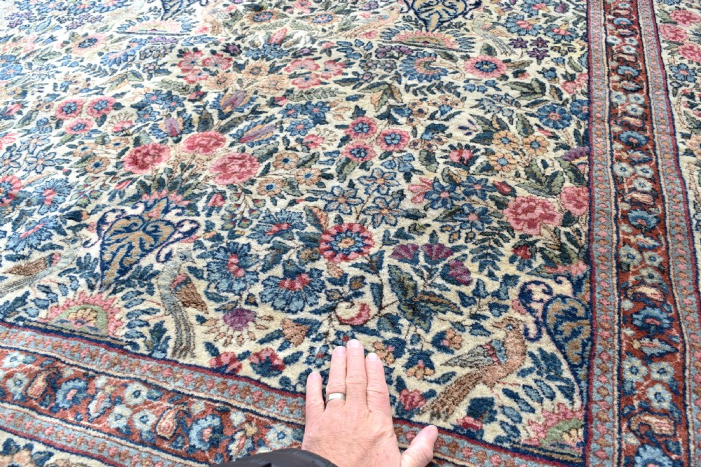 A large hand-knotted Persian Kirman room-size carpet featuring an intricate floral and vase pattern in cream, rose pink, and slate blue. View V