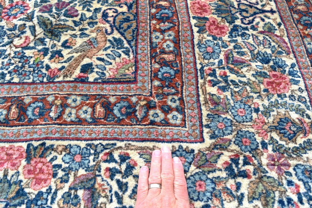 A large hand-knotted Persian Kirman room-size carpet featuring an intricate floral and vase pattern in cream, rose pink, and slate blue. View VI